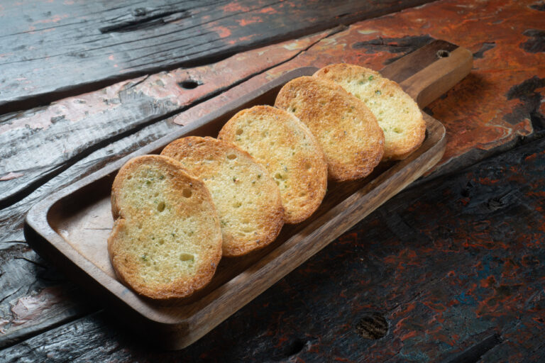 Smoked pork crostini topped with arugula and goat cheese
