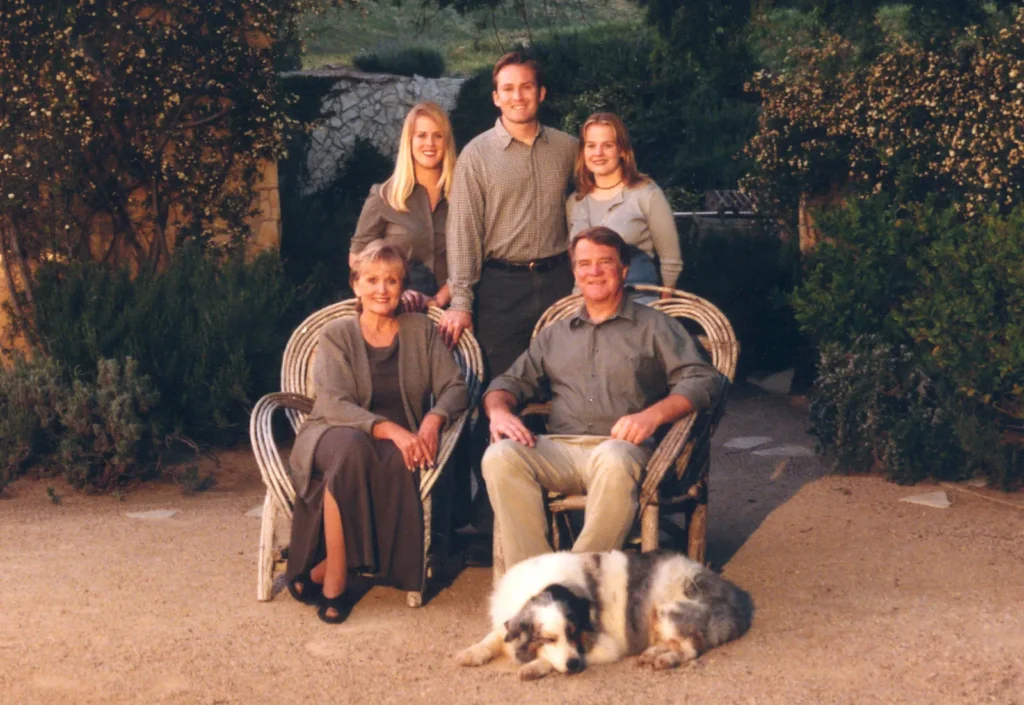 The founding family seated outdoors in the Sunstone courtyard with their dog
