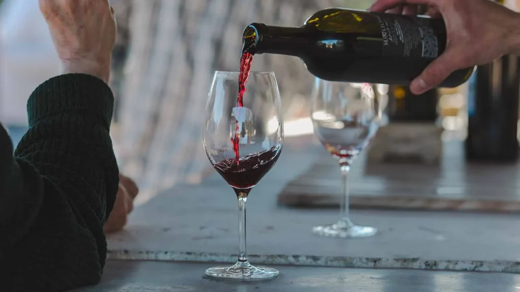 Red wine being poured into a glass at a Sunstone tasting
