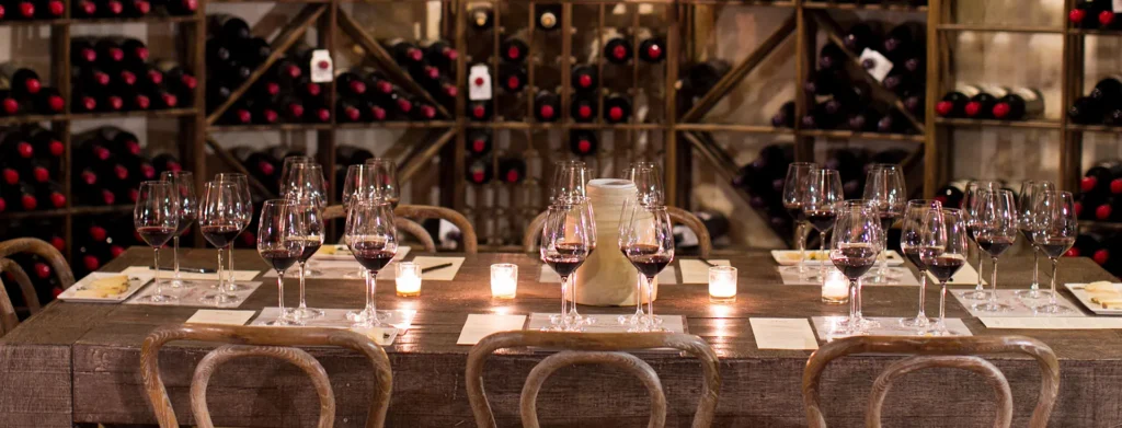 A long table set for a private tasting in front of the wine racks