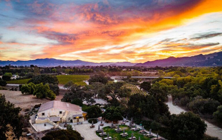 The Sunstone winery and its courtyard from the air at sunset, with the Santa Ynez Valley beyond